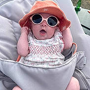 Adèle participe au concours pour gagner de l'argent avec cette photo : baby, infant, sunglasses, hat, baby_seat, outdoor, clothing, sun_hat, pink, white, patterned_dress, expression, cute, child, summer, shade, accessory, relaxing, person, seat