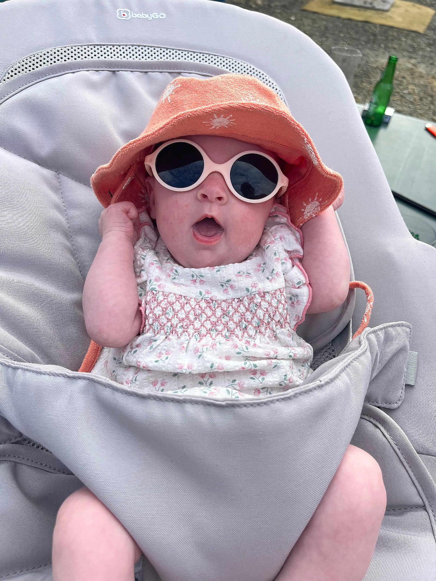 Adèle participe au concours pour gagner de l'argent avec cette photo : baby, infant, sunglasses, hat, baby_seat, outdoor, clothing, sun_hat, pink, white, patterned_dress, expression, cute, child, summer, shade, accessory, relaxing, person, seat