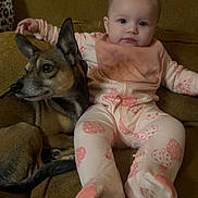 Ellie joined the competition — help win amazing prizes! baby, infant, dog, couch, pajamas, butterfly_pattern, pet, animal, child, indoor, furniture, relaxing, cute, young_child, portrait, companionship, cozy, casual, home, seated