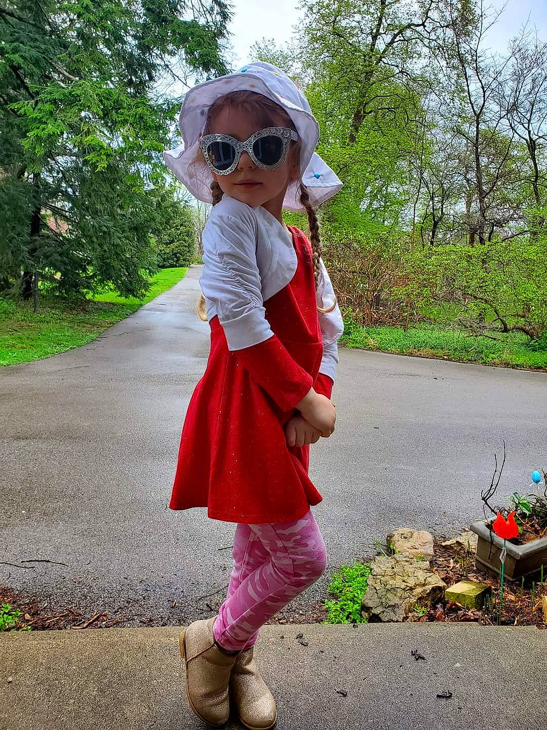 Kylie is registered to the contest to win money with this photo: arm, asphalt, eyewear, footwear, glasses, goggles, grass, knee, leisure, magenta, person, pink, plant, road, shoe, sleeve, street_fashion, sunglasses, tree, vision_care