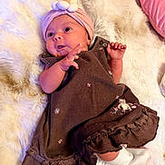Lillie is registered to the contest to win money with this photo: baby, infant, child, blanket, headband, dress, pink, brown, embroidery, socks, lying_down, curious, cute, soft_texture, indoor, portrait, small_hands, fluffy, cozy, person