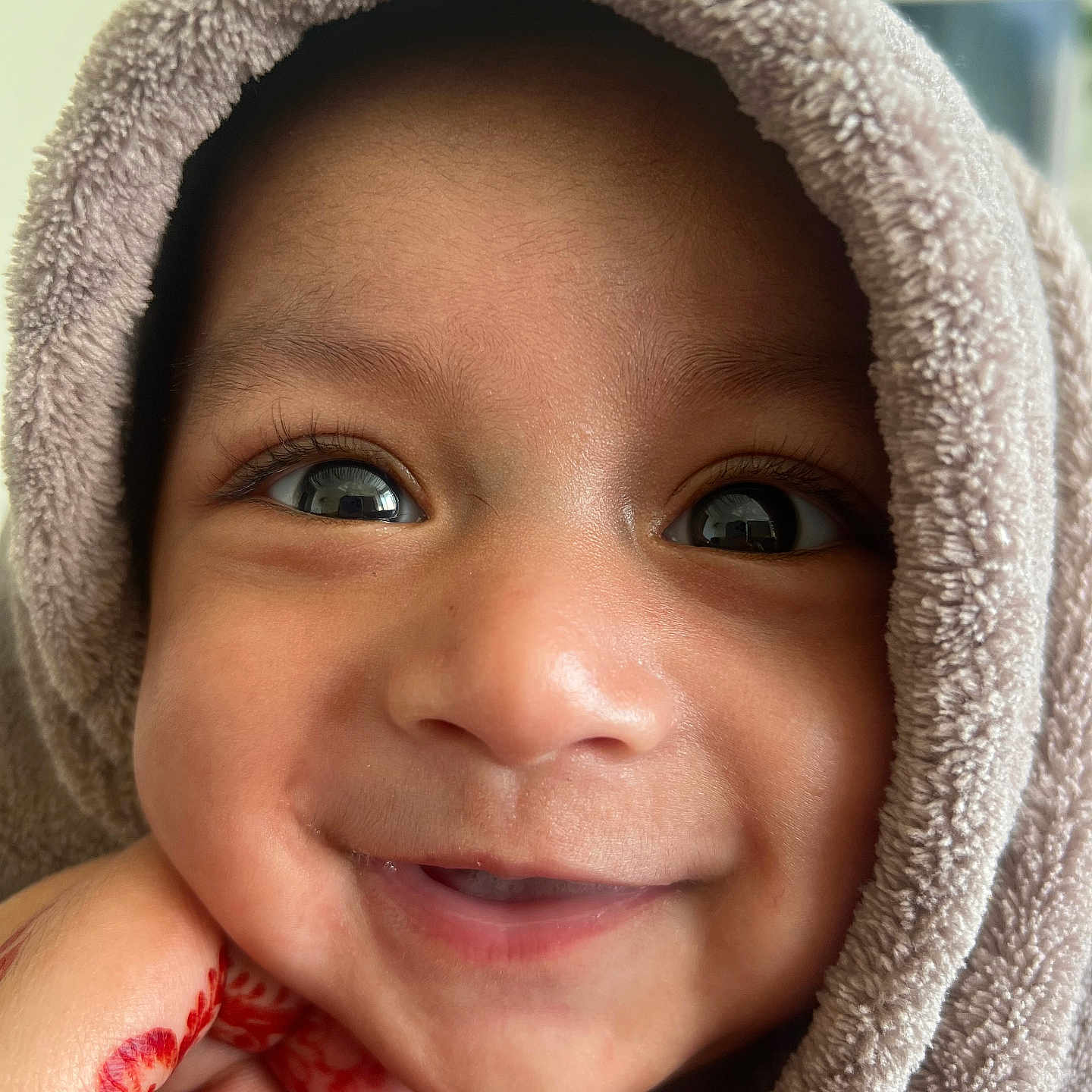 Ayaan a rejoint le concours — aidez-le/la à gagner de superbes lots ! baby, smile, face, child, towel, hand, henna, close_up, portrait, cute, happy, skin, eyes, fingers, soft_texture, warm, infant, expression, wrapped, indoors