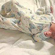Kalena is registered to the contest to win money with this photo: newborn, baby, infant, sleeping, lying_down, bed, blanket, white_bedding, pajamas, clothing, bow, headband, face, hands, feet, indoors, portrait, soft_lighting, nursery, family_photo