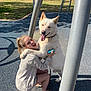 Fang joined the competition — help win amazing prizes! woman, dog, white_dog, hugging, playground, outdoor, smiling, happy, leash, casual_clothing, sunny, grass, fence, metal_poles, shoes, shorts, play_equipment, tongue_out, light_hair, kneeling