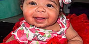 Ocean is registered to the contest to win money with this photo: baby, child, smiling, headband, red_dress, tutu, indoor, cute, happy, infant, clothing, person, portrait, sitting, closeup, hand, curly_hair, face, baby_girl, expression