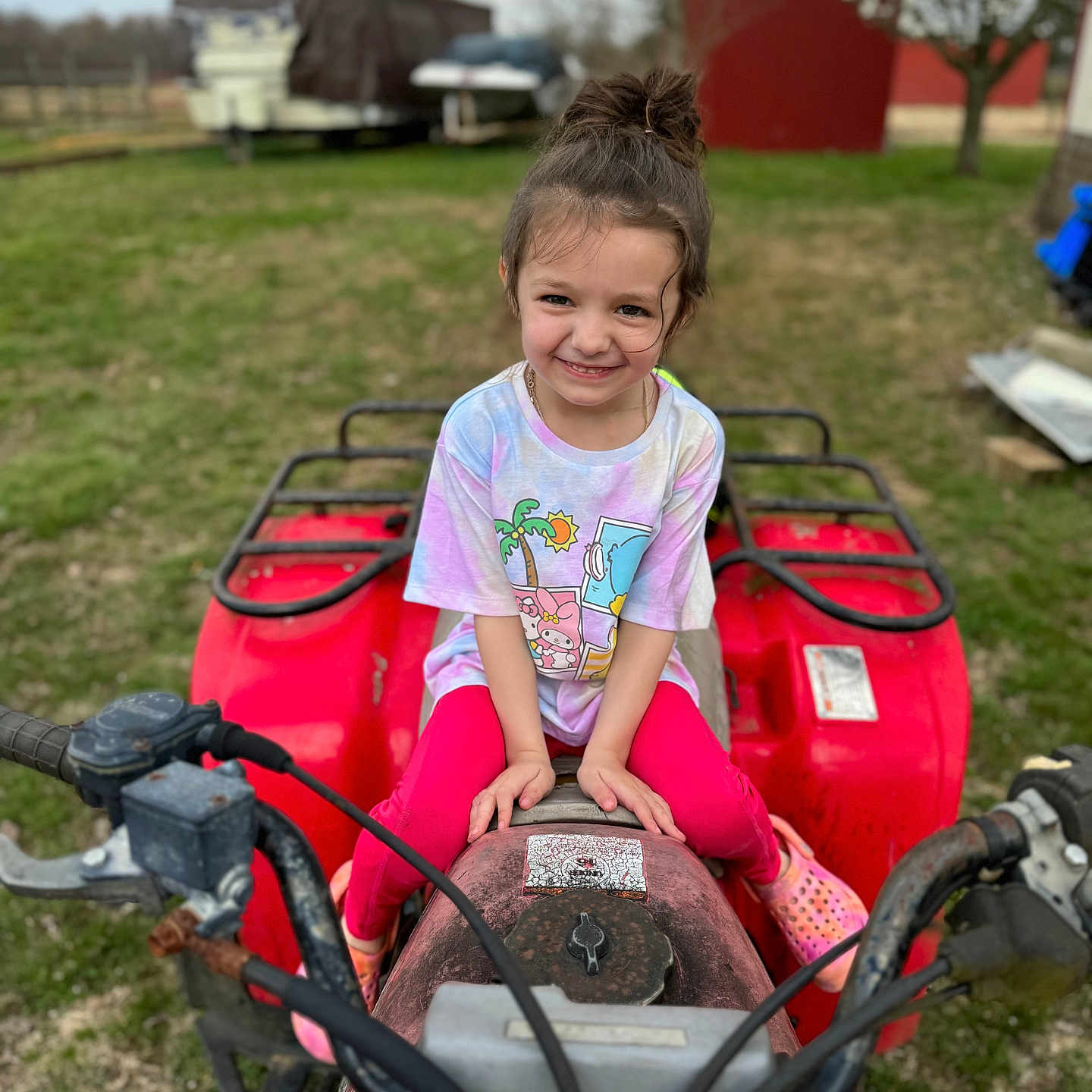 Aurora is registered to the contest to win money with this photo: atv, casual, child, clothing, daytime, farm, fun, girl, grass, happy, nature, outdoor, person, playful, red, smile, toy, tree, vehicle, young