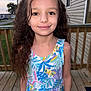 child, girl, smile, curly_hair, dress, colorful, outdoor, deck, wooden, suburban, house, evening, portrait, young, person, happy, nature, leaf_pattern, fashion, casual