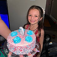 Aurora joined the competition — help win amazing prizes! child, girl, birthday_cake, cake, candle, smile, party, celebration, colorful, sprinkles, frosting, long_hair, necklace, red_dress, indoor, home, happy, holding, nail_polish, person