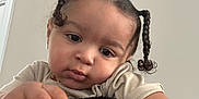 Jahmarii joined the competition — help win amazing prizes! black_blanket, braids, brown_skin, casual, cheese_puff, child, closeup, curious, expression, face, food, hair_ties, hand, indoor, neutral_expression, person, short_sleeve, snack, toddler, young_child