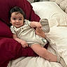 baby, child, infant, smiling, portrait, sitting, lying_down, bed, pillows, blanket, home, bedroom, furniture, sock, foot, clothing, indoor, cozy, happy, photography