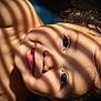 child, face, smile, curly_hair, sunlight, shadows, close_up, portrait, happy, skin, eyes, expression, indoors, natural_light, head, baby, cheeks, young, innocence, warmth