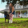 Duke is registered to the contest to win money with this photo: bandana, blue_dress, canine, daylight, dog, fall_leaves, grass, greenery, happy, home, house, leash, outdoor, pet, porch, portrait, smiling, tree, white_boots, woman