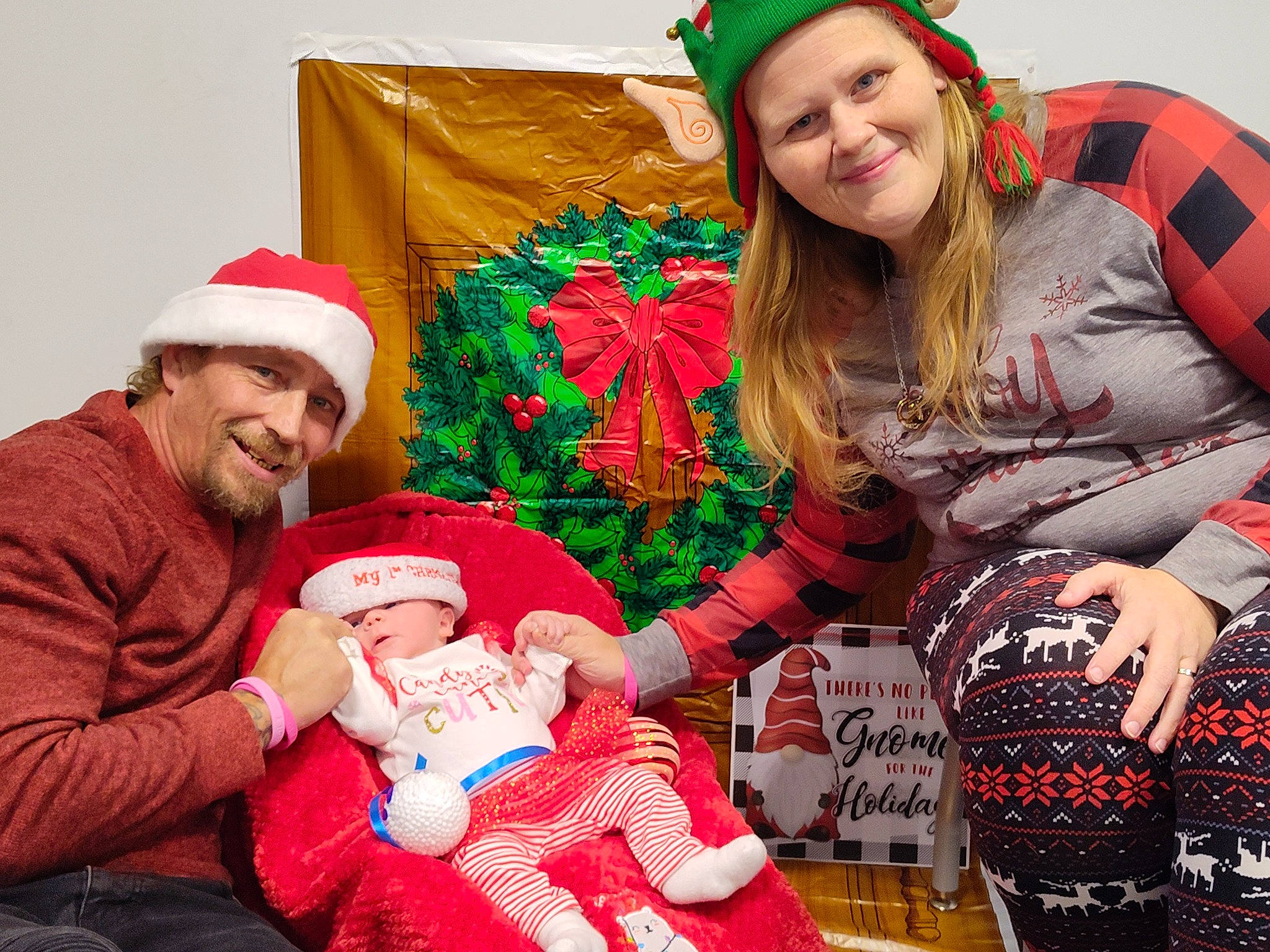 Jolie joined the competition — help win amazing prizes! baby, christmas, christmas_decoration, christmas_eve, clothing, event, face, facial_expression, fun, green, happy, hat, headwear, holiday, joy, lap, person, red, santa_claus, sleeve