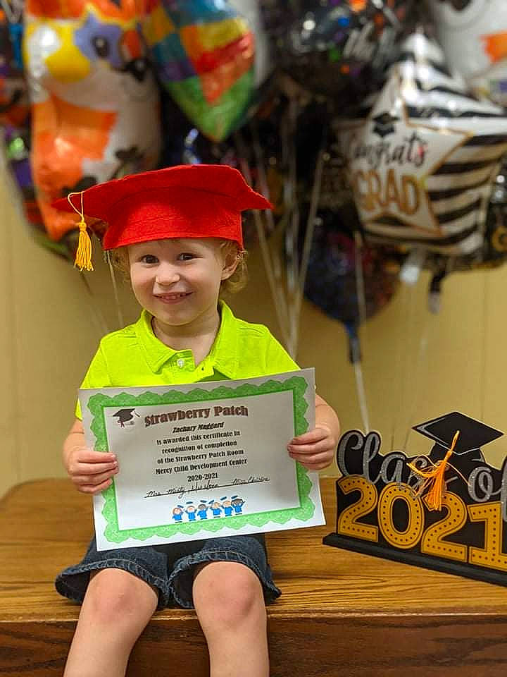 Zach is registered to the contest to win money with this photo: baseball_cap, cap, child, community, costume, event, fun, happy, headwear, holiday, joy, kindergarten, logo, party_supply, person, public_event, room, smile, t_shirt, toddler