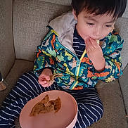 Gerson joined the competition — help win amazing prizes! boy, casual, child, colorful_clothing, comfort, couch, dinosaur_jacket, eating, face, food, hand, indoor, meal, plate, portrait, relaxed, seated, snack, striped_pants, young_child