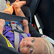 Kaysen is registered to the contest to win money with this photo: baby, car_seat, child, blue_eyes, seatbelt, infant, safety, car_interior, blond_hair, cute, looking_up, hands, feet, purple_clothing, toddler, child_safety, car, seat, young_child, portrait