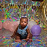 baby, balloons, birthday, celebration, child, colorful, cute, decorations, denim_overalls, floor, gold_letters, hair_bows, holographic_background, indoor, infant, milestone, party, pastel_colors, portrait, sitting