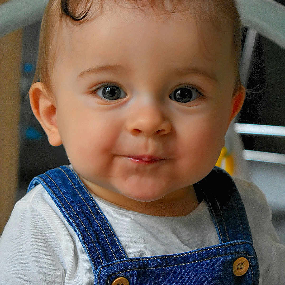 Raphaël a rejoint le concours — aidez-le/la à gagner de superbes lots ! baby, button, child, clothing, cute, denim_overalls, eyes, face, hair, head, indoor, infant, person, portrait, sitting, skin, smile, toddler, white_shirt, young