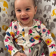 Hîvda Róisín joined the competition — help win amazing prizes! baby, smiling, infant, floral_clothing, onesie, baby_seat, elephant_pattern, happy, child, cute, face, hands, sitting, indoor, colorful, patterned_fabric, young, portrait, baby_girl, joyful