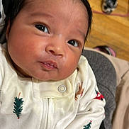 Elysaida joined the competition — help win amazing prizes! baby, infant, newborn, face, eyes, hair, onesie, embroidered_pattern, christmas_tree, reindeer, hardwood_floor, sneaker, background, closeup, portrait, hand, skin, cozy, indoors, clothing