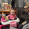 baby, walker, smile, indoor, living_room, lamp, table, photo_frame, curtain, toy, pink, blanket, sofa, cushion, child, person, happy, furniture, car_seat, cozy