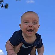Liam joined the competition — help win amazing prizes! baby, child, smiling, happy, outdoor, sky, playground, tree, arms, person, holding, blue_sky, daylight, infant, cute, fun, nature, hands, park, summer