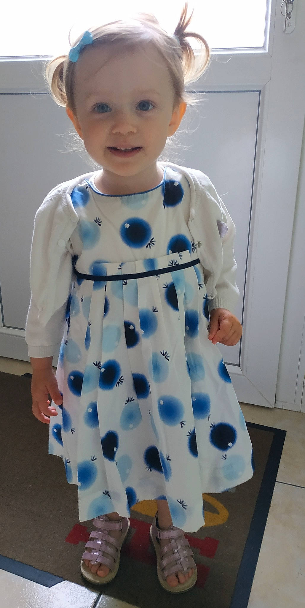 Maëline participe au concours pour gagner de l'argent avec cette photo : arm, baby_toddler_clothing, blue, child, collar, costume, day_dress, dress, electric_blue, event, happy, one_piece_garment, pattern, person, room, sleeve, smile, standing, toddler, uniform