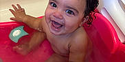 Tyla is registered to the contest to win money with this photo: baby, bathtub, child, bath, water, smile, happy, hand, toy, curl_hair, skin, playful, pink, bathroom, sitting, wet, cute, infant, holding_hand, expression