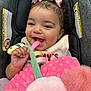 Tyla joined the competition — help win amazing prizes! baby, child, smiling, curly_hair, pink_bows, car_seat, soft_toy, blanket, infant, happy, cute, portrait, indoors, closeup, hand, fabric, person, seat, comfort, playful