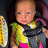 baby, child, car_seat, safety_harness, clothing, infant, seatbelt, portrait, person, cute, serious, indoors, seat, head, face, hand, expression, closeup, colorful, safety