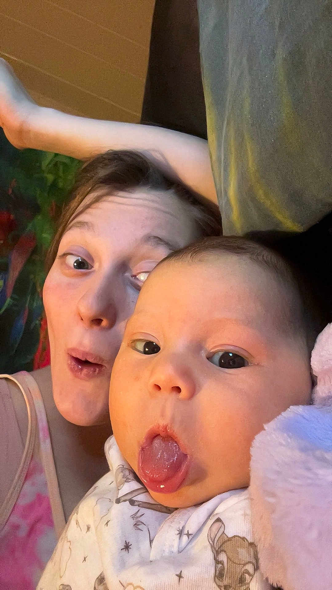 Nellie joined the competition — help win amazing prizes! baby, adult, face, tongue, expression, funny_face, selfie, indoor, person, child, blanket, clothing, soft_toy, head, skin, eyes, mouth, happy, cute, cozy