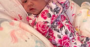 Elyanna is registered to the contest to win money with this photo: baby, blanket, child, cozy, cute, fabric, floral_clothing, flower_headband, headwear, indoor, infant, newborn, pattern, person, pink, portrait, sleepy, soft, unicorn, wrapped