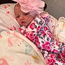 baby, infant, blanket, flower_headband, pink, floral_clothing, sleepy, cute, soft, cozy, wrapped, unicorn, pattern, fabric, portrait, child, newborn, indoor, person, headwear