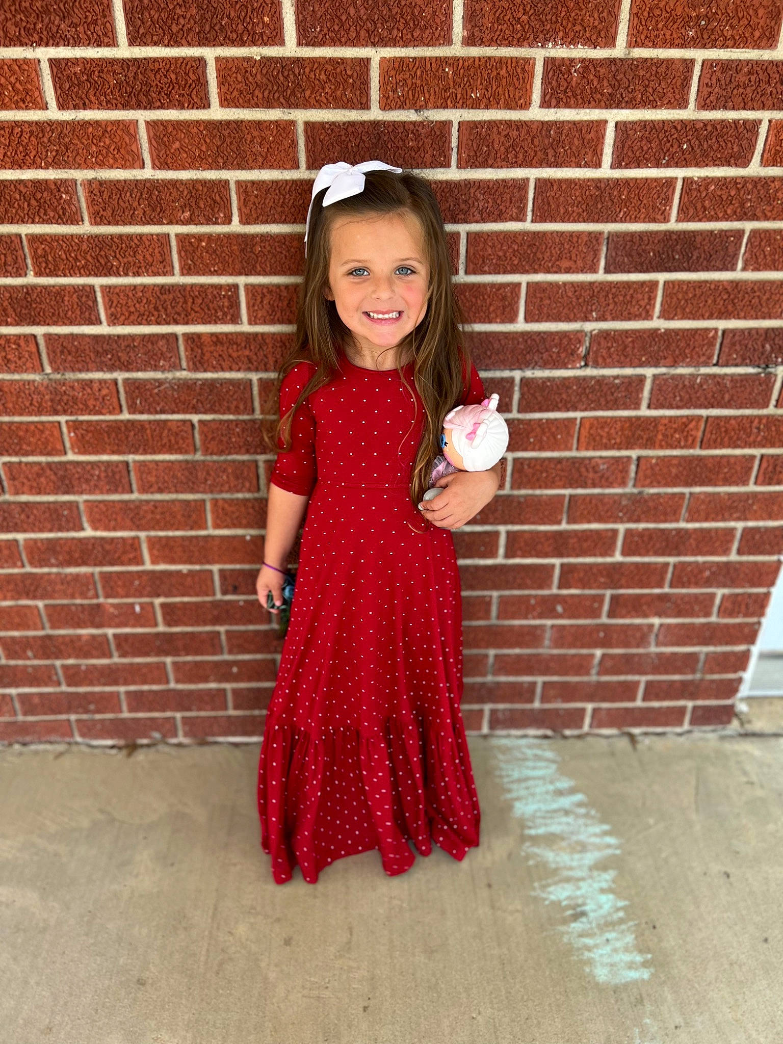 Kenli Pennington is registered to the contest to win money with this photo: arm, brick, dress, eye, face, floor, flooring, hair, hand, head, human_body, joy, leg, neck, one_piece_garment, outerwear, person, pink, sleeve, smile