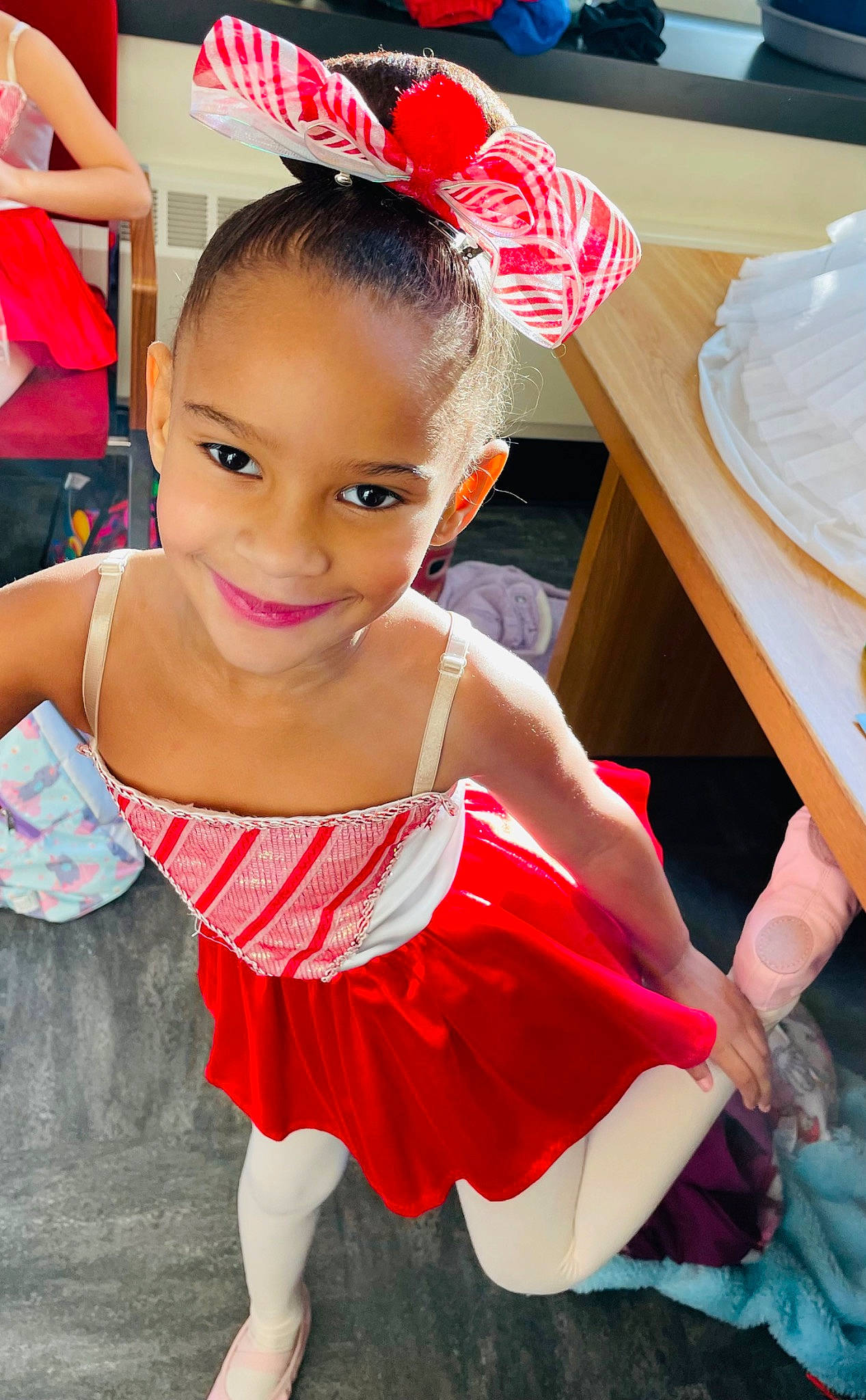 Caylee is registered to the contest to win money with this photo: baby_toddler_clothing, chair, child, event, facial_expression, fashion_accessory, fashion_design, fun, happy, human_leg, joy, leisure, magenta, person, pink, red, ruffle, skin, smile, table