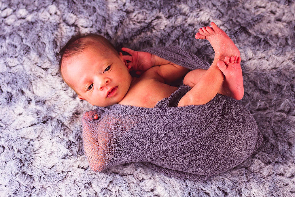 Aurora is registered to the contest to win money with this photo: arm, baby, comfort, eye, finger, grass, grey, hair, hand, head, human_body, leg, mammal, people_in_nature, person, pink, plant, skin, textile, vertebrate