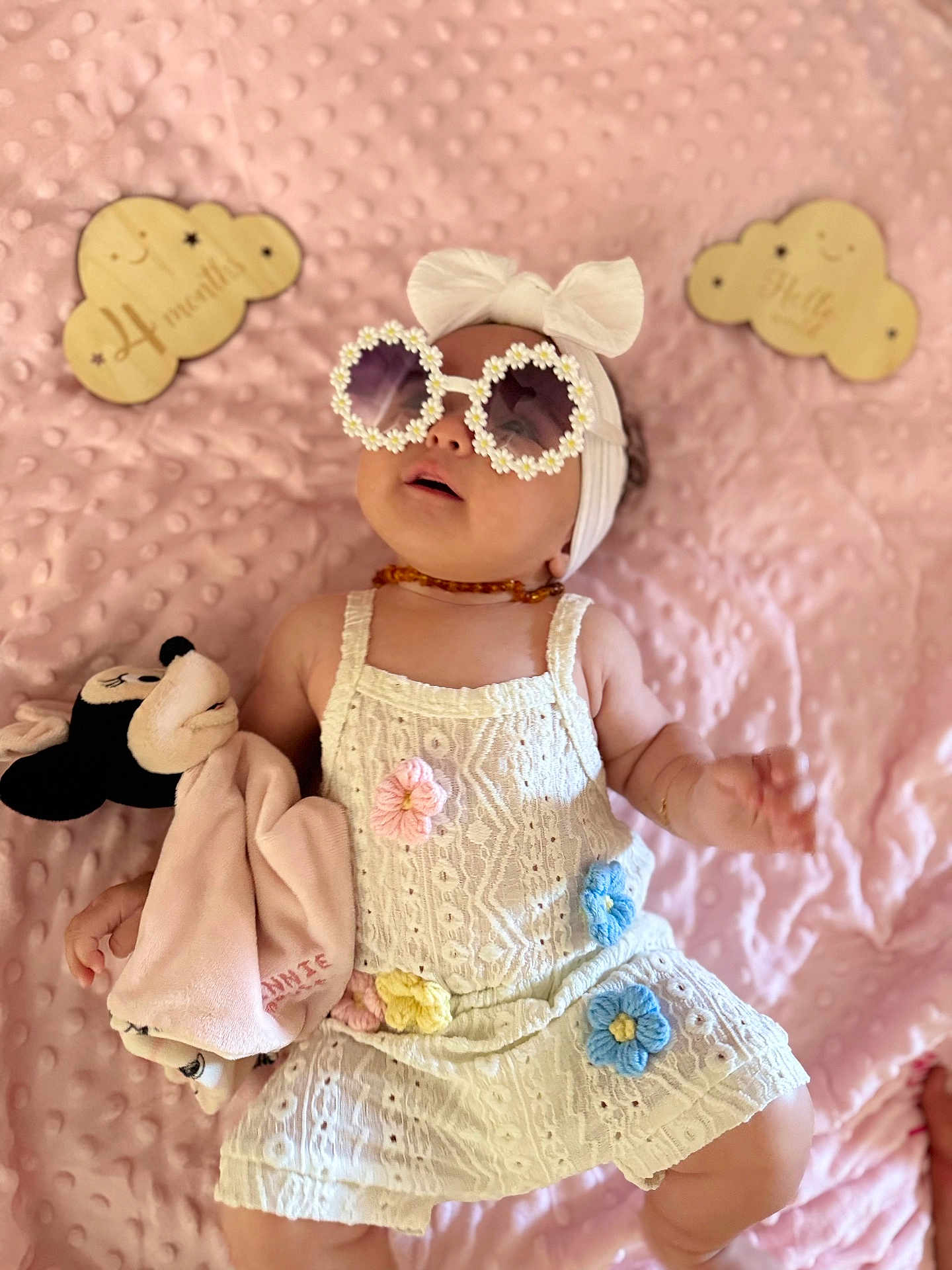 Ilyana participe au concours pour gagner de l'argent avec cette photo : baby, infant, sunglasses, headband, dress, plush_toy, minnie_mouse, blanket, pink, flower, crochet, wooden_sign, milestone, cute, child, smile, lying_down, accessory, soft_toy, portrait