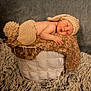 baby, newborn, sleeping, knitted_hat, knitted_diaper_cover, basket, blanket, fur_rug, soft_texture, neutral_background, cozy, infant, cute, resting, portrait, indoors, warm_colors, peaceful, child, person