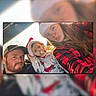 Judson is registered to the contest to win money with this photo: family, toddler, man, woman, santa_hat, pacifier, plaid_shirt, cap, car_interior, holiday, christmas, selfie, smile, tongue_out, casual_clothing, beard, long_hair, child, portrait, indoors