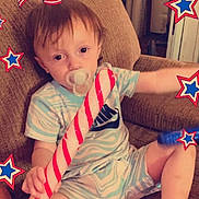 Judson is registered to the contest to win money with this photo: toddler, child, pacifier, candy_cane, pajamas, couch, indoor, 4th_of_july, independence_day, decorations, stars, holiday, celebration, american_flag, happy, cute, sitting, young_child, home, festive