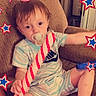 toddler, child, pacifier, candy_cane, pajamas, couch, indoor, 4th_of_july, independence_day, decorations, stars, holiday, celebration, american_flag, happy, cute, sitting, young_child, home, festive