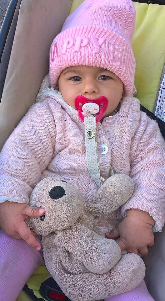 Julie participe au concours pour gagner de l'argent avec cette photo : cap, child, headgear, headwear, infant, knit_cap, knitting, nose, person, pink, product, skin, stuffed_toy, textile, toddler, toy, wool