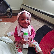 Heaven is registered to the contest to win money with this photo: baby, beverage, bodypart, bonnet, bottle, cap, clothing, face, finger, hand, hardwood, hat, head, milk, person, photography, portrait, shaker, sitting, wood