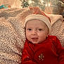 baby, infant, face, smiling, red_clothing, santa_hat, blanket, christmas_tree, holiday, decorations, lights, festive, indoors, cozy, child, portrait, cute, seasonal, happy, celebration