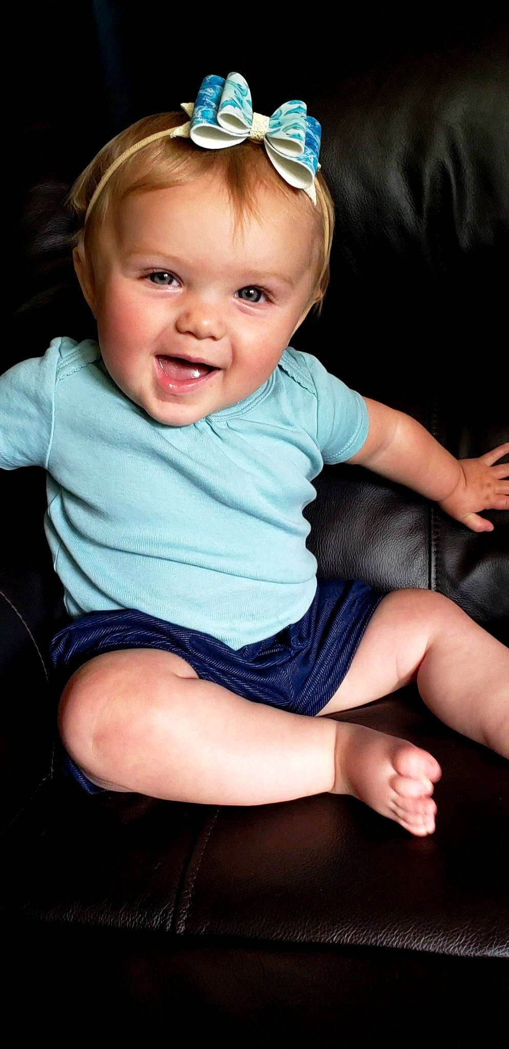 Annie is registered to the contest to win money with this photo: arm, baby_toddler_clothing, black, blue, cheek, eye, face, facial_expression, flash_photography, hand, human_body, iris, leg, lip, neck, organ, person, skin, sleeve, smile