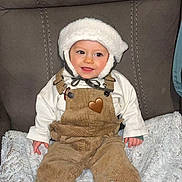 Thibaut a rejoint le concours — aidez-le/la à gagner de superbes lots ! baby, black_shoes, blanket, chair, child, corduroy, cushion, cute, footwear, happy, hat, indoors, overalls, person, plush, portrait, seated, smiling, toddler, warm_clothing