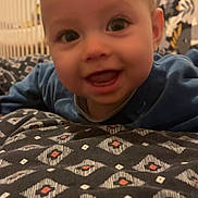 Thibaut a rejoint le concours — aidez-le/la à gagner de superbes lots ! baby, infant, smiling, face, blanket, crib, pattern, blue_clothing, indoors, child, cute, portrait, happy, young_child, wallpaper, head, person, furniture, room, closeup