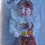 Ayla joined the competition — help win amazing prizes! baby, infant, headband, smiling, clothing, pumpkin, turkey, blanket, fall_theme, patterned_pants, lying_down, cute, child, autumn_colors, portrait, happy, decor, fabric, person, holiday