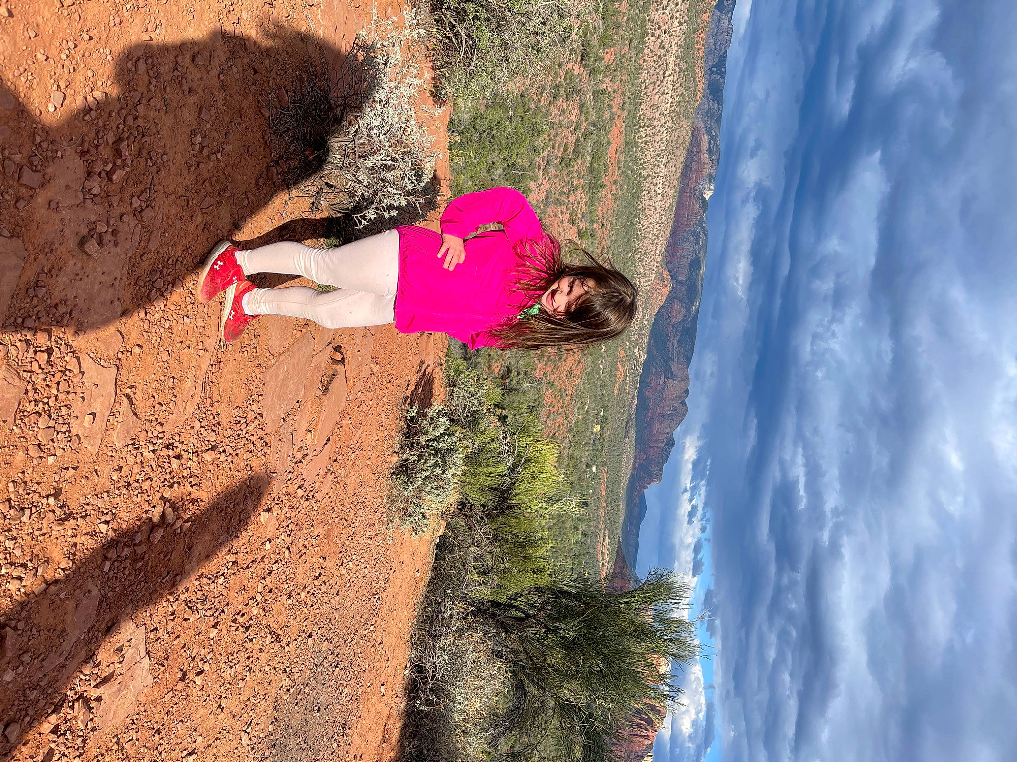 Brooklyn is registered to the contest to win money with this photo: adventure, bedrock, body_of_water, cloud, coast, formation, fun, joy, landscape, leisure, outcrop, people_in_nature, person, plant, recreation, rock, sky, slope, soil, terrain