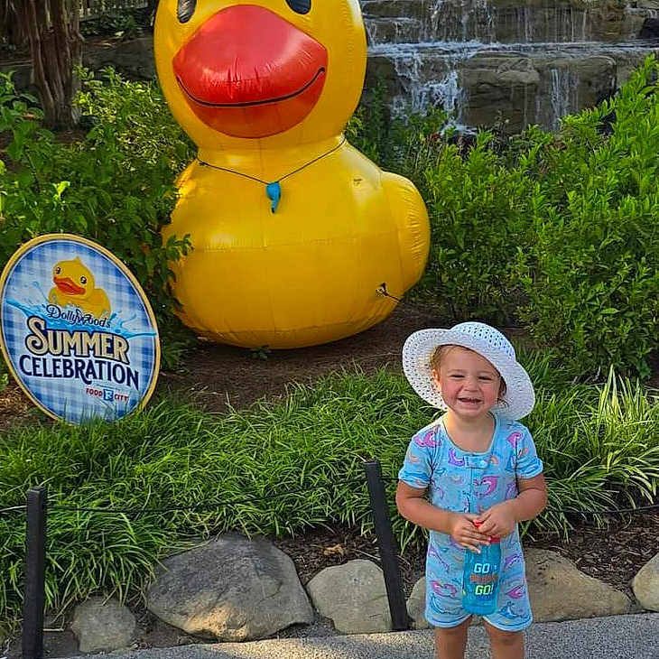 Laylah is registered to the contest to win money with this photo: animal, child, clothing, face, female, girl, grass, hat, head, nature, outdoors, park, person, photography, plant, portrait, rock, vegetation, water, zoo